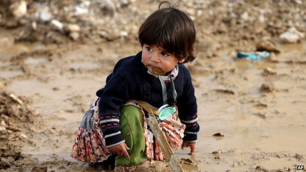 Syrian refugee girl sits on mud at a refugee camp, in the eastern Lebanese Town of Al-Faour near the border with Syria, Lebanon, on 2 December 2014.