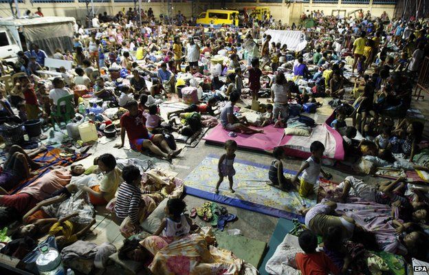 Filipino residents take shelter inside a gymnasium turned into a temporary evacuation center in Mambaling village, Cebu province, central Philippines, 05 December 2014