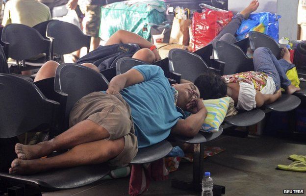 Stranded passengers sleep on chairs as ferry ships cancel in anticipation of Typhoon Hagupit at the north harbour in Manila December 5, 2014