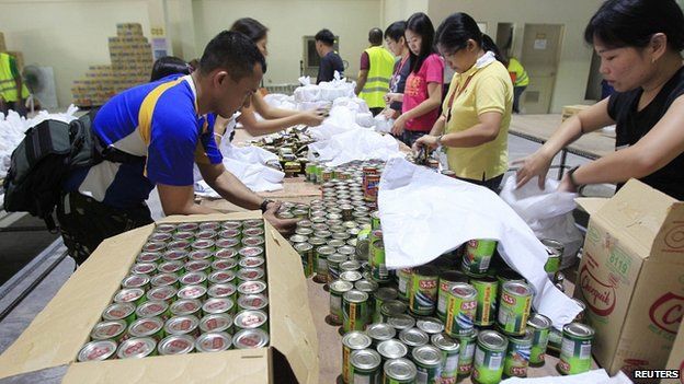 Soldiers and volunteers prepare relief goods inside warehouse in Manila. 6 Dec 2014