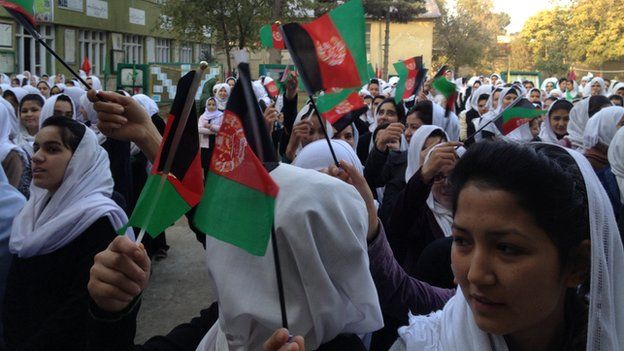 Rita Faizi (front) and her classmates hold flags