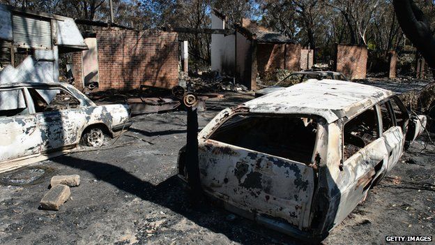 Burnt out cars sits in front of a destroyed house at Mount Victoria in the Blue Mountains. 21 Oct 2013