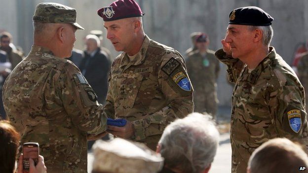 International Security Assistance Force Joint Command (IJC), Lieutenant General Joseph Anderson, center, hands over the flag of the IJC to commander of International Security Assistance Force, General John F. Campbell, left, a ceremony in Kabul, Afghanistan, Monday, Dec. 8, 2014.
