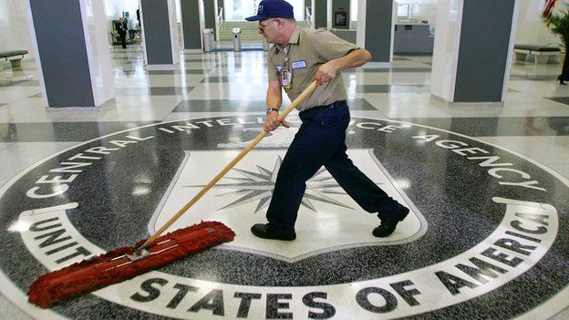 A janitor sweeps over the seal of the Central Intelligence Agency.