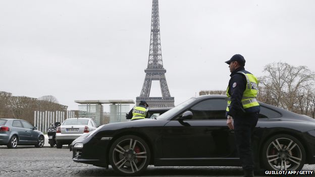 Police officers control cars in front of the Eiffel Tower, in Paris, on March 17, 2014