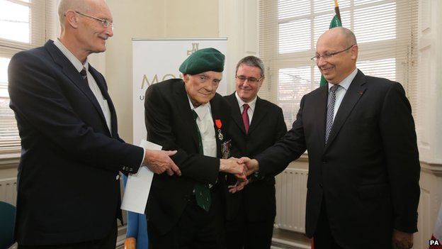 Pat Gillen, flanked by his two sons Robin (left) and Gerard (right), as he is presented with the the Legion d"Honneur from French Ambassador Jean-Pierre Thebault