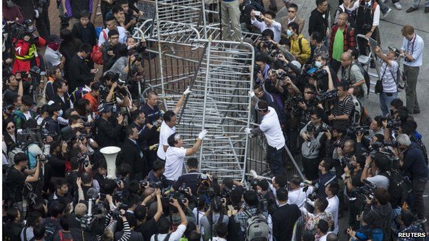 Building employees dismantle a barricade outside Citic Tower in accordance with a court injunction to clear up part of the protest site, outside the government headquarters in Hong Kong 18 November 2014.
