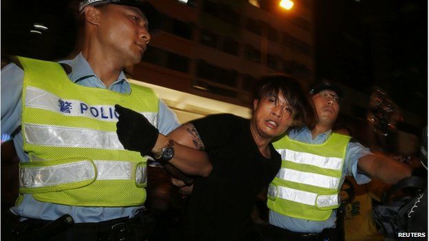 An anti-Occupy Central protester is detained by policemen after he broke through a cordon line, trying to charge pro-democracy protesters, at Hong Kong's shopping Mong Kok district, where a main road is occupied, 3 October 2014.