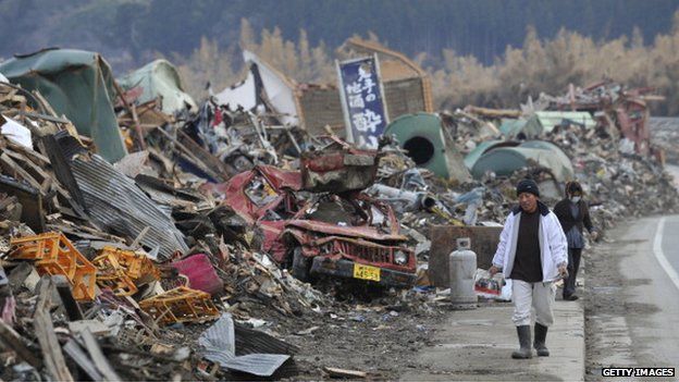 A couple walk through tsunami damage in Iwate in April 2011