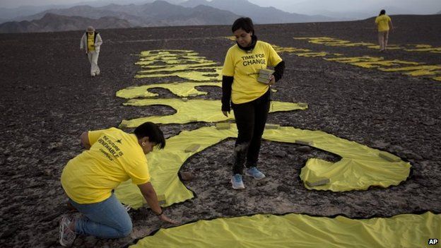 Greenpeace activists arrange the letters delivering the message "Time for Change: The Future is Renewable" next to the hummingbird geoglyph in Nazca on 8 December, 2014.