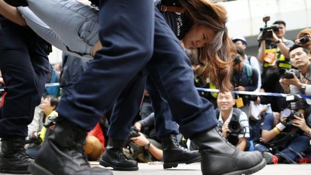 A demonstrator is taken away by police from an area previously blocked by pro-democracy supporters, outside the government headquarters in Hong Kong, 11 December 2014.
