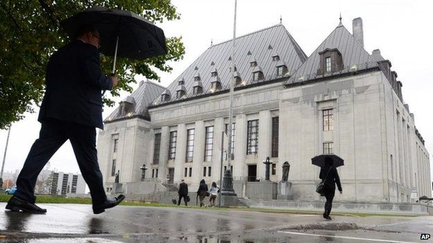 People walk outside the Supreme Court of Canada 15 October 2014 in Ottawa, Ontario.