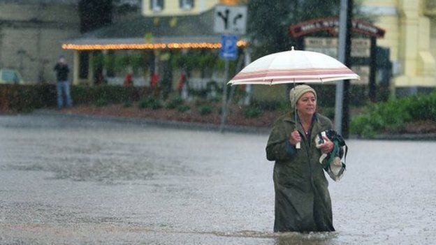 A woman makes her way through floodwaters in Healdsburg, California