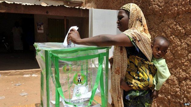 A Nigerian woman carrying her baby casts her vote at a polling station in Nigeria's presidential elections - 16 April 2011