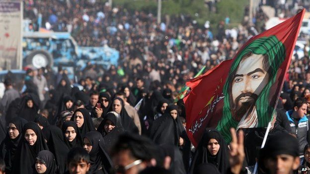 Pilgrims carrying a banner of Imam Hussain, a figure worshipped by Shia Muslims
