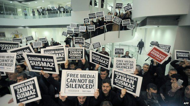 Zaman journalists hold banners inside the newspaper's headquarters in Istanbul.