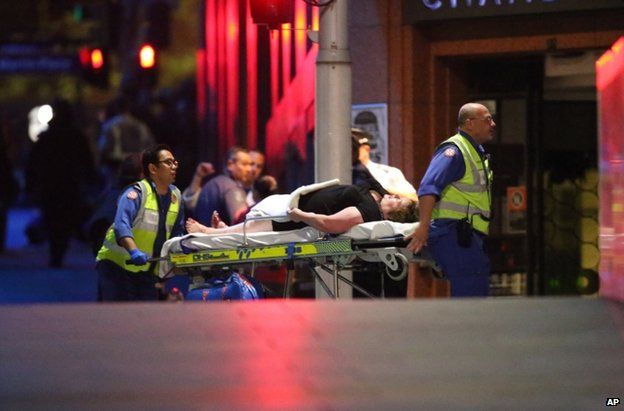 An injured man is wheeled to an ambulance in Sydney, 15 December