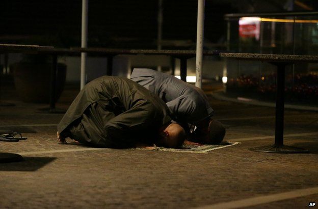 Two Muslims pray for peace in the central business district of Sydney, 16 December