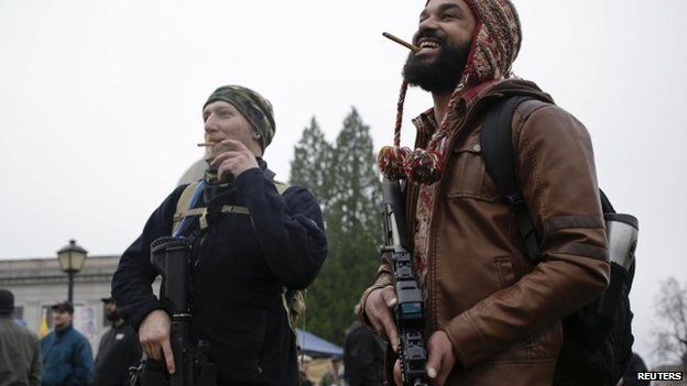 Douglas MacPhail Reynolds (L) and Chris Williams smoke cigars as gun rights advocates rally against Initiative 594 at the state capitol in Olympia, Washington 13 December 2014