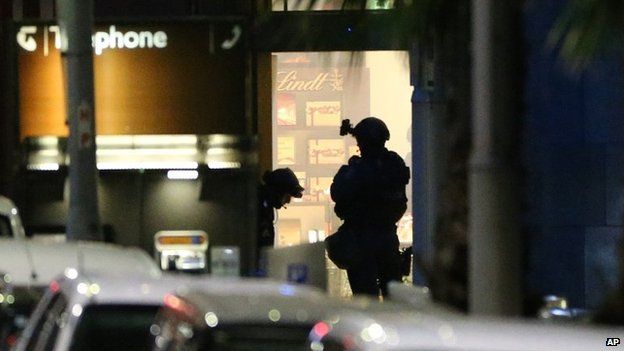 Armed tactical response officers stand ready to enter the Lindt cafe during a siege in Sydney on 16 December 2014