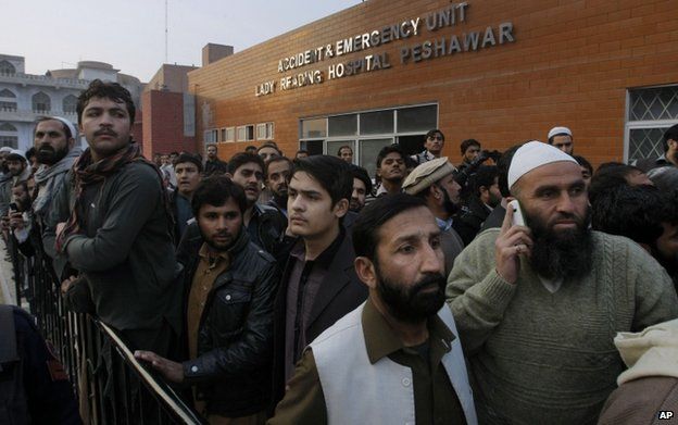 Relatives wait outside a hospital in Peshawar, 16 December