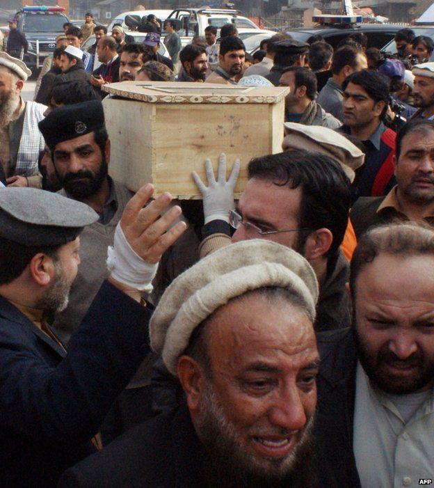 Mourners carry the coffin of a student from a hospital in Peshawar, 16 December
