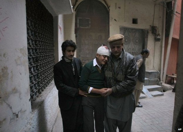 Relatives comfort injured student Mohammad Baqair in Peshawar, 16 December