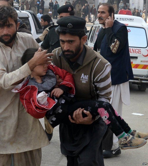 An injured girl is carried to hospital in Peshawar, 16 December