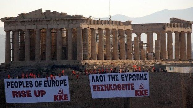 Members of Communist Party of Greece (KKE) wave flags from the Acropolis Hill, and display large banners from the front Parthenon Temple on May 4, 2010 in Athens