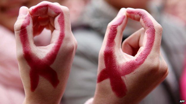 Students show their hands painted to look like red ribbons during a world AIDS day event at a school in Hanshan, central China's Anhui province on 30 November.
