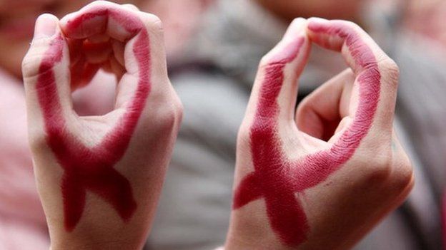 Students show their hands painted to look like red ribbons during a world AIDS day event at a school in Hanshan, central China's Anhui province on 30 November.