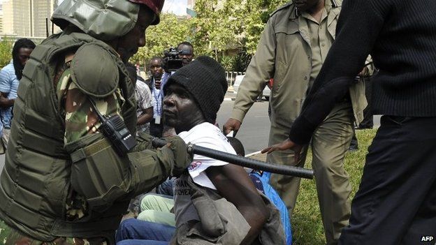 Policemen arrest a man protesting about controversial new security legislation outside parliament 18 December 18 2014 in Nairobi, Kenya