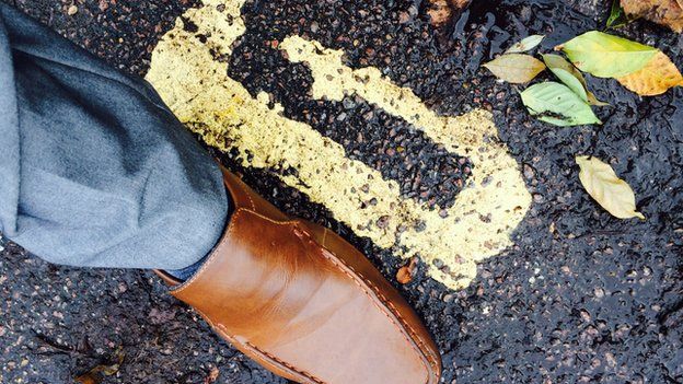 Man's foot measuring double yellow lines