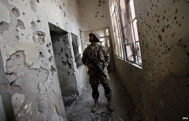 A Pakistani army soldier looks at a bullet ridden wall of the Army Public School that was attacked by Taliban militants, in Peshawar, Pakistan, 18 December 2014