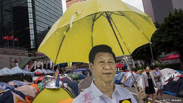 A cardboard cut-out of Chinese president Xi Jinping holding a yellow umbrella, the symbol of the movement, is seen outside a tent used by pro-democracy protesters at the Admiralty protest site on 13 November, 2014 in Hong Kong