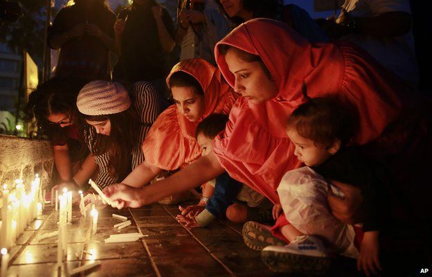 Indians lights candles during a prayer meeting in memory of the victims of Tuesday"s Taliban attack in Peshawar, in Mumbai, India,Thursday, Dec. 18, 2014