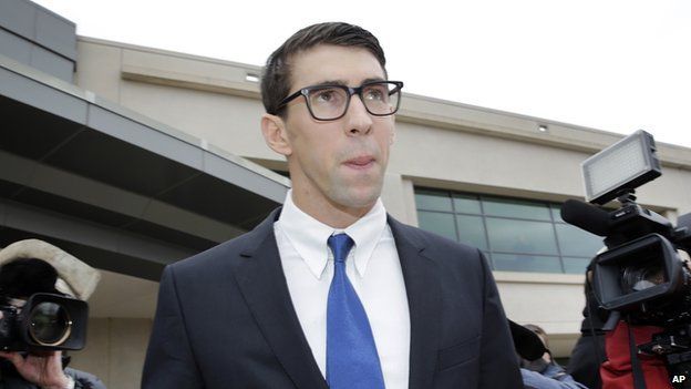 Olympic swimmer Michael Phelps walks out of a courthouse after pleading guilty to drunken driving, Friday, Dec. 19, 2014, in Baltimore