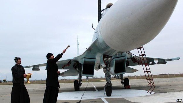 A Russian Orthodox priest blesses a SU-27 SM fighter jet at Belbek military airport near Sevastopol, 26 Nov