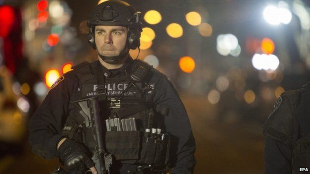 A police officer guards the shooting scene in New York, 20 December