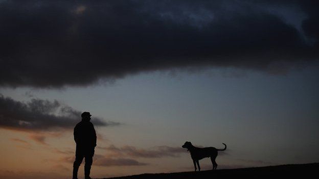 Man and dog on dark winter morning
