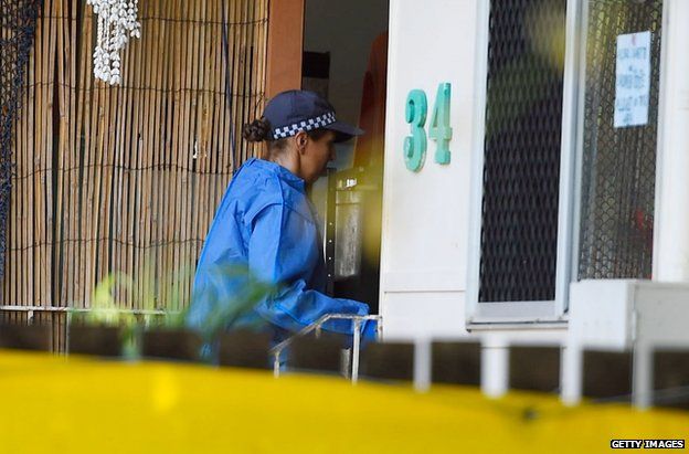 A policewoman enters the house where the murders took place in Cairns, Australia, 21 December