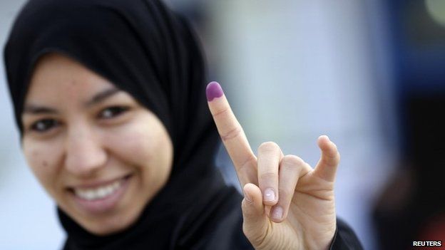 A voter in Tunisia displays an ink-stained finger having voted in elections