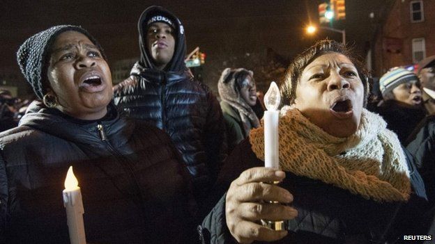 Prayers and songs at vigils for the officers shot dead in New York