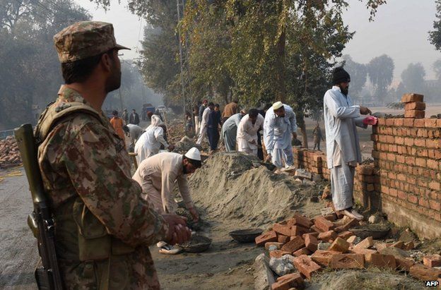 Labourers build a wall at the school attacked in Peshawar, 21 December