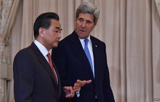 US Secretary of State John Kerry (R) speaks to Chinese Foreign Minister Wang Yi as they arrive to meet the press prior to talks in Washington, DC on 1 October 2014.