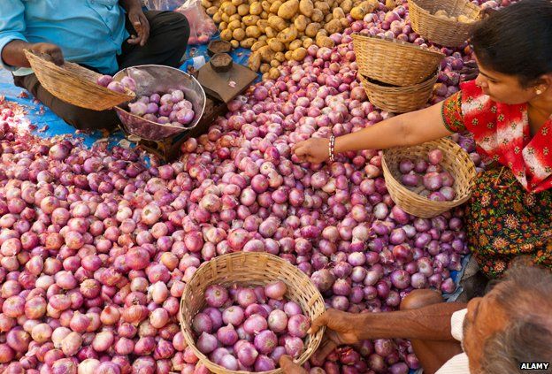 Customers buying onions at a market in India