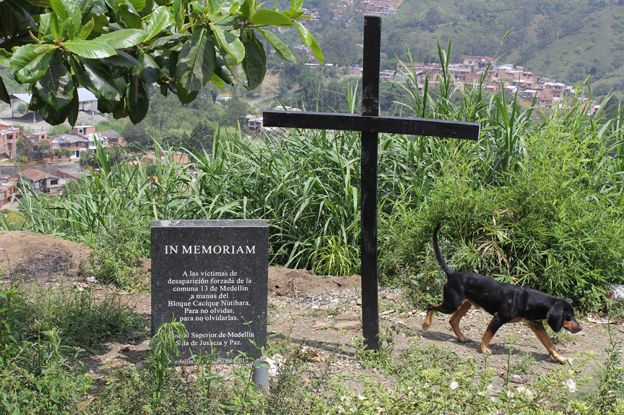 A cross by a stone in memory of the disappeared
