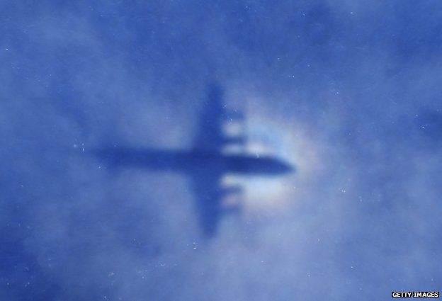 Shadow of a Royal New Zealand Air Force P3 Orion aircraft is seen on low cloud cover while it searches for missing Malaysia Airlines flight MH370, over the Indian Ocean on March 31,