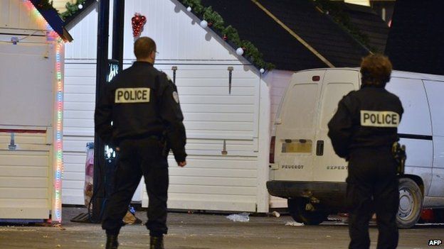 Police stand on the site where a the driver of a van (seen in picture) ploughed into a Christmas market injuring at least ten people before stabbing himself in the western French city of Nantes, 22 December 2014