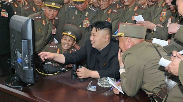 An undated handout picture released by the North Korean Central News Agency (KCNA) on 27 April 2014 shows North Korean leader Kim Jong-un (C) looking at a computer screen along with soldiers of a long-range artillery unit at an undisclosed location in North Korea.